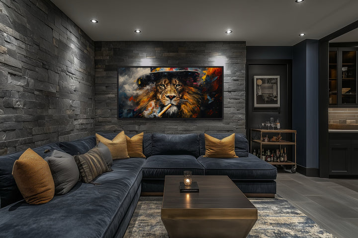 Framed canvas print of a lion smoking a cigar on a stone wall above a blue sectional sofa.