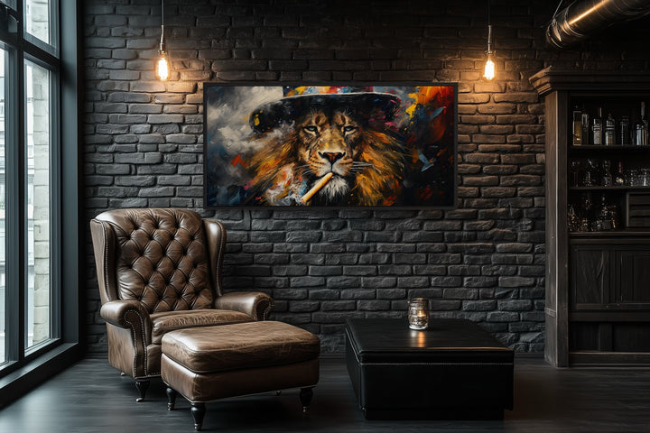 Framed canvas print of a lion smoking a cigar in a dark room with a leather chair and ottoman.