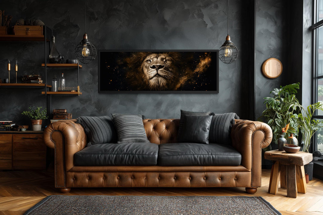 A long narrow canvas print of a majestic lion's face in black and gold above a leather sofa.