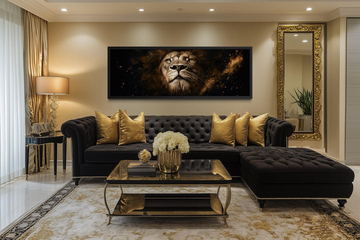 A majestic lion portrait canvas in black and gold hangs above a luxury black tufted sofa.