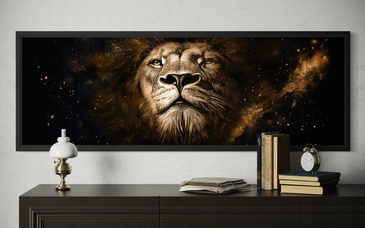 A long narrow canvas print of a majestic lion's face in black and gold tones on a dark wall.