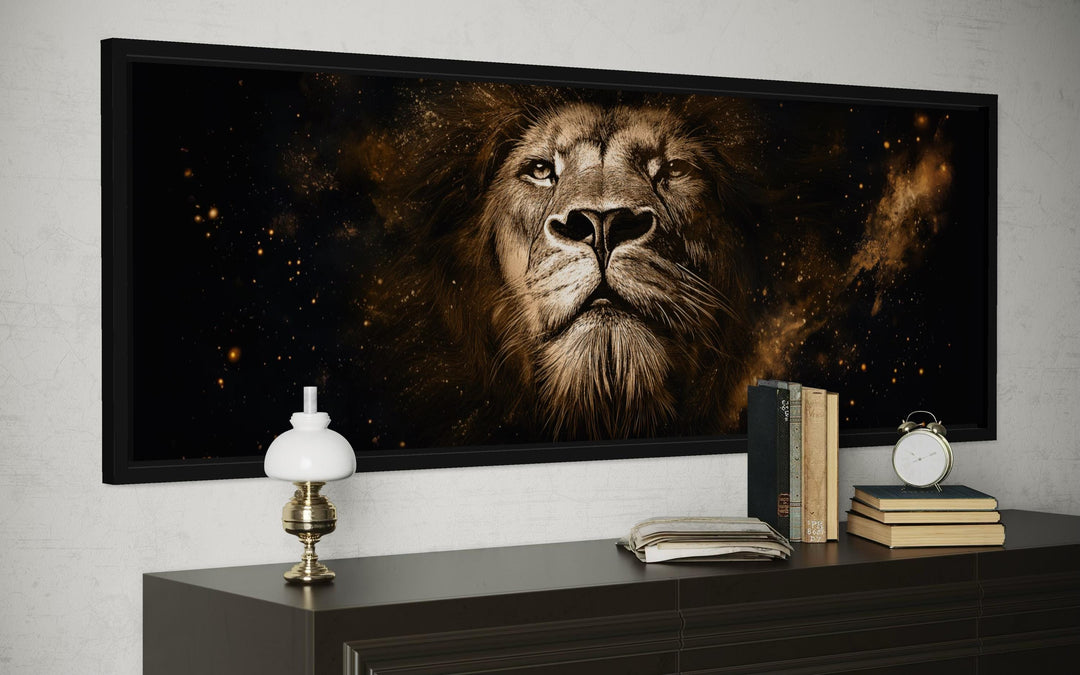 A long narrow canvas print of a majestic lion's face in black and gold tones on a dark wall.