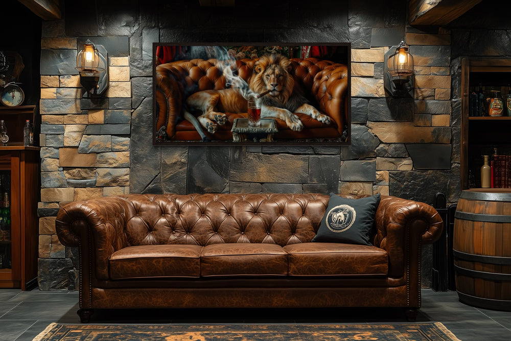 Lion on the couch smoking a cigar framed canvas print hanging above a brown leather sofa.