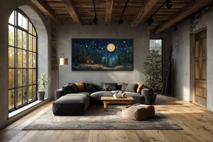 Log Cabin in the Moonlit Woods canvas wall art hanging in a rustic living room.