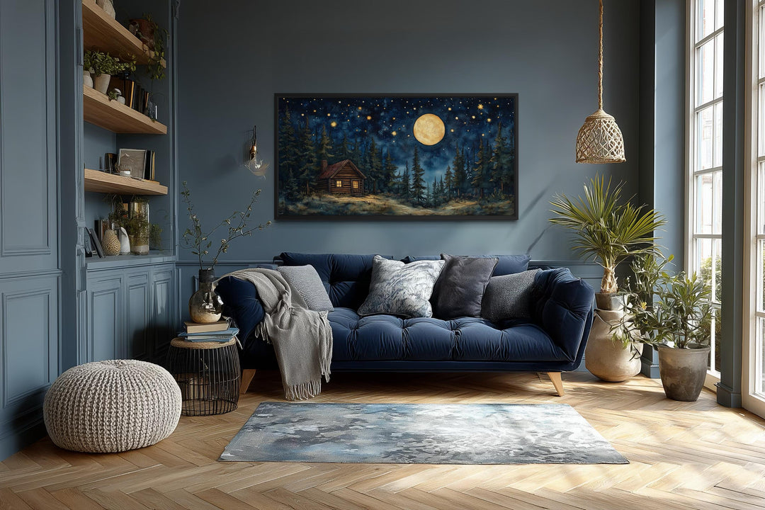 Log Cabin in the Moonlit Woods canvas wall art hanging in a cozy, modern living room.