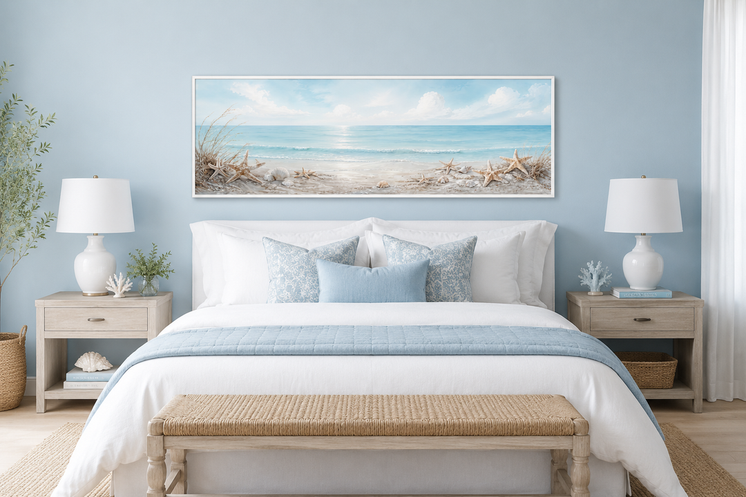 Long horizontal beach wall art with seashells and starfish above a bed in a coastal bedroom.