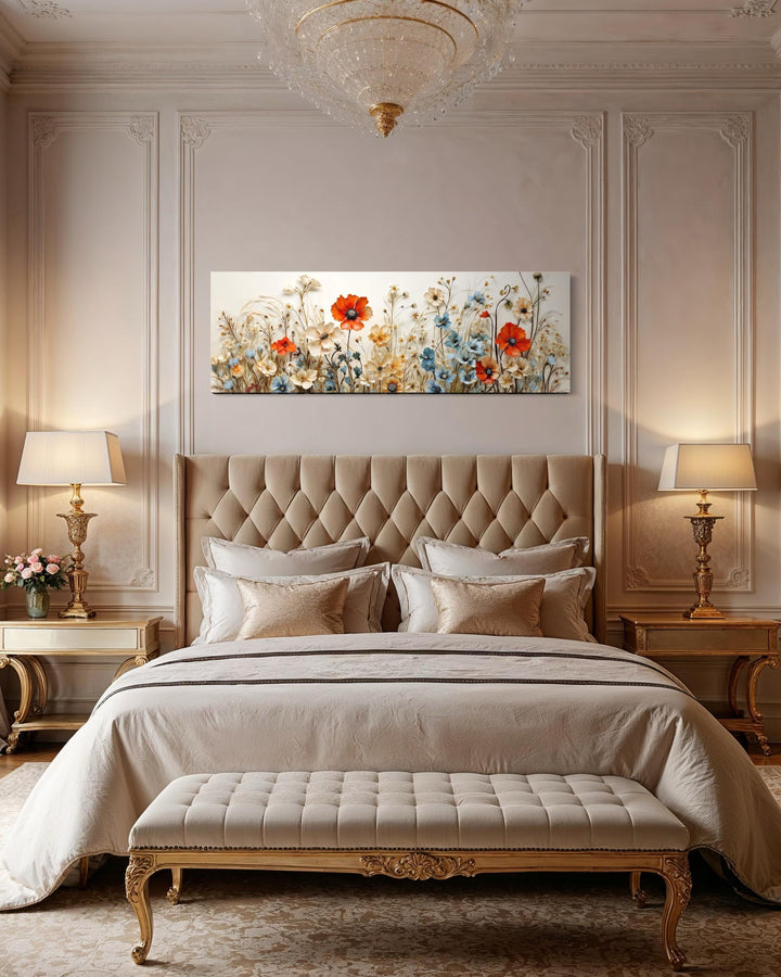 Long horizontal canvas wall art featuring red poppies and blue flowers above a tufted headboard.