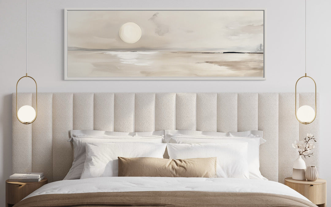 Long horizontal neutral coastal landscape wall art with a moon above a modern upholstered bed.