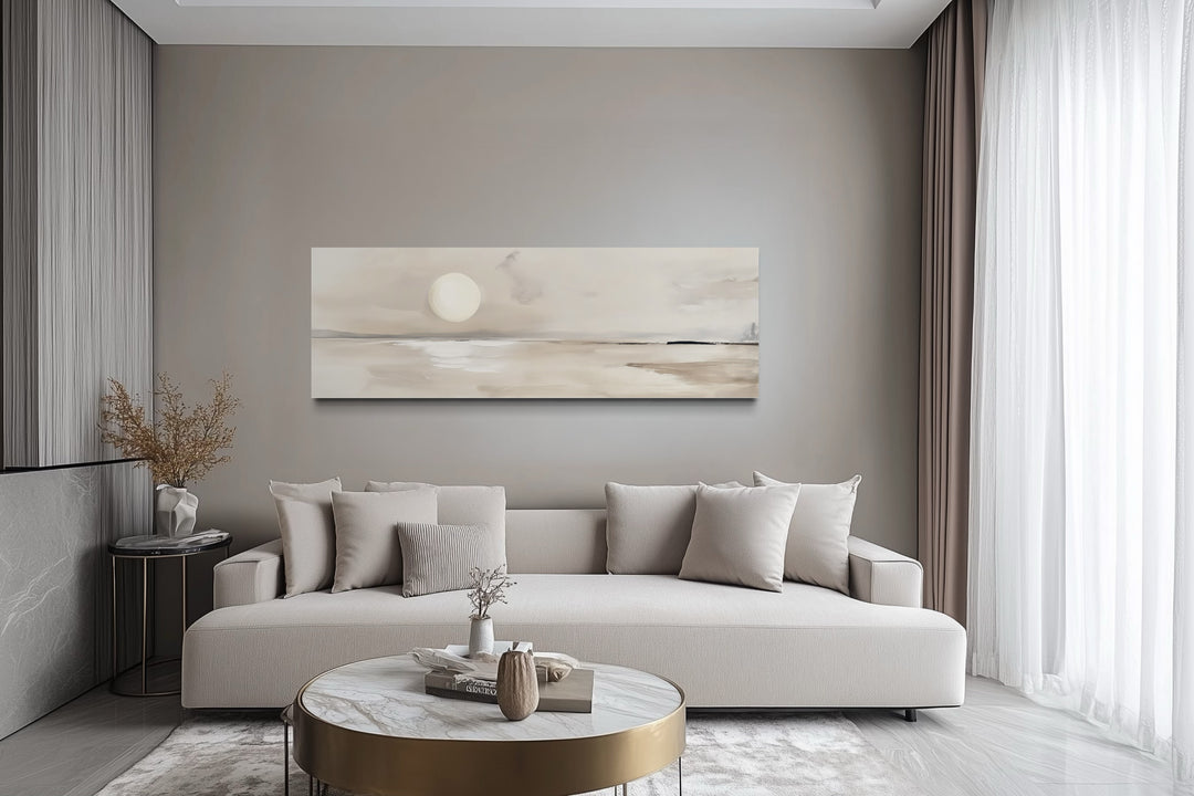 Long horizontal neutral coastal landscape canvas wall art with a moon above a sofa in a modern room.