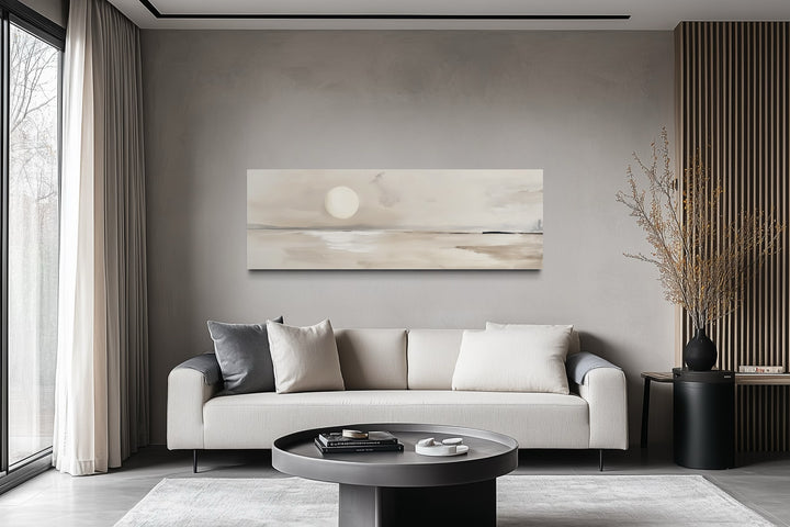 Long horizontal neutral coastal landscape canvas art with a glowing moon above a modern sofa.