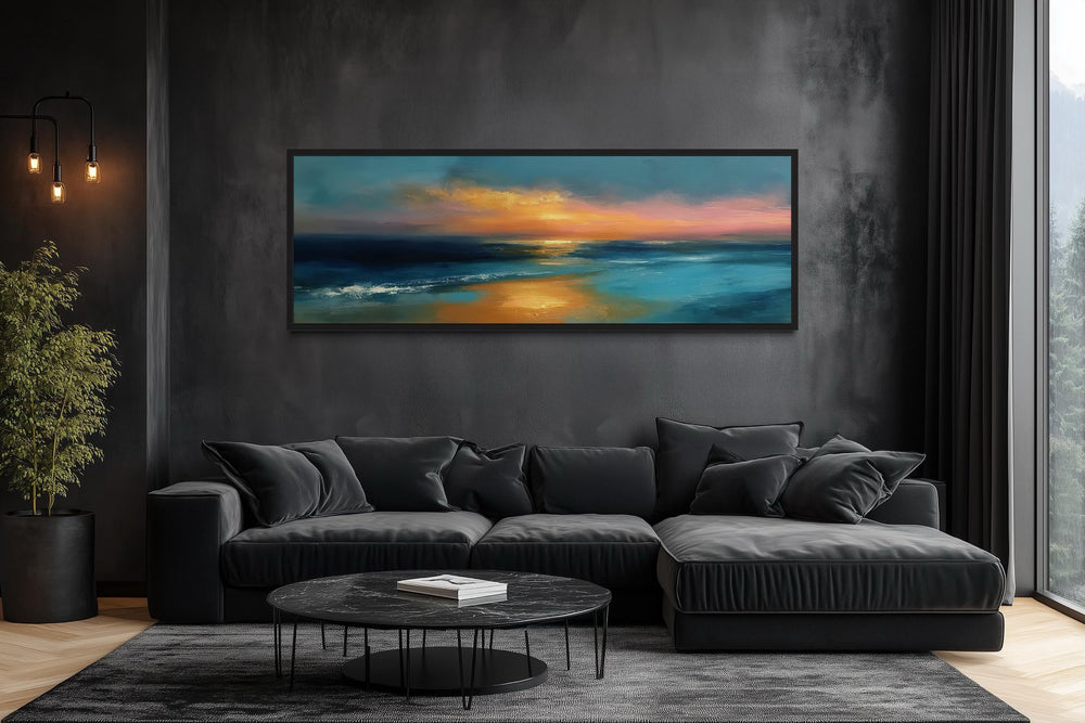 Long horizontal panoramic seascape wall art of an ocean sunset over a black sofa in a modern room.