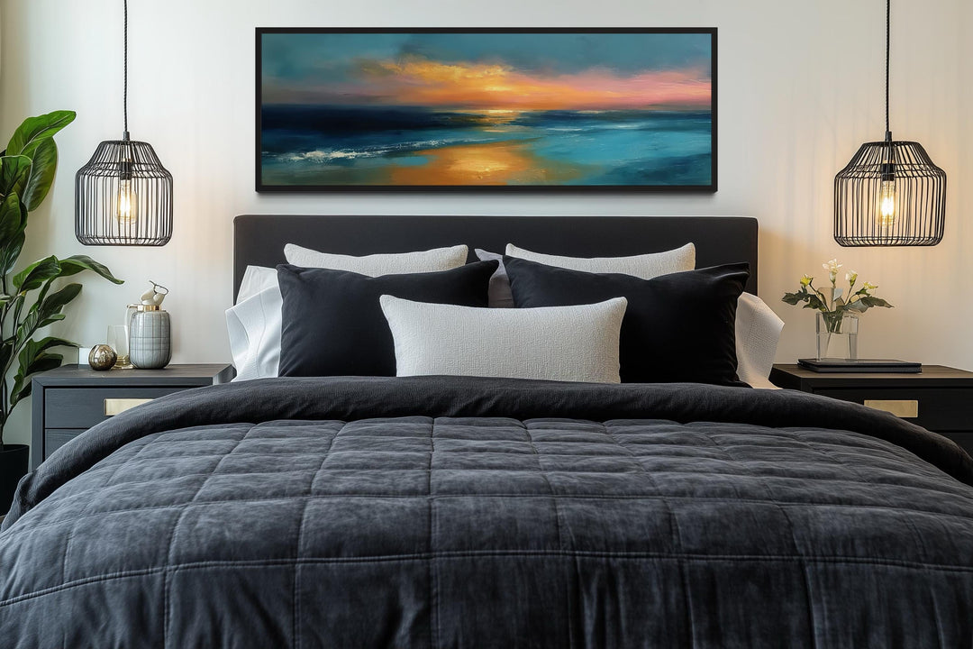 Panoramic seascape wall art with an orange sunset over blue ocean waves above a modern bed.