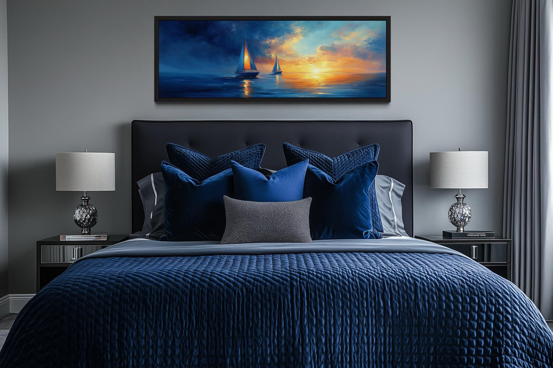 Long horizontal canvas wall art of sailboats on a blue ocean during a vibrant orange sunset.