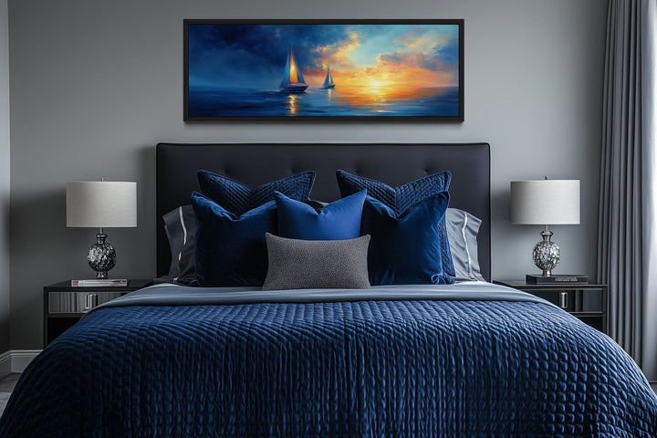 Long horizontal canvas wall art of sailboats on a blue ocean during a vibrant orange sunset.