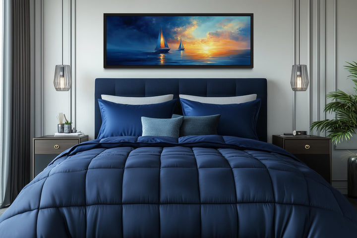 Long horizontal canvas wall art of sailboats on a calm ocean during a vibrant sunset.