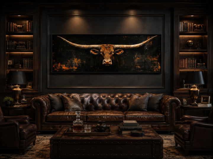 Long horizontal Texas longhorn bull head on a black rustic canvas wall art above a leather sofa.