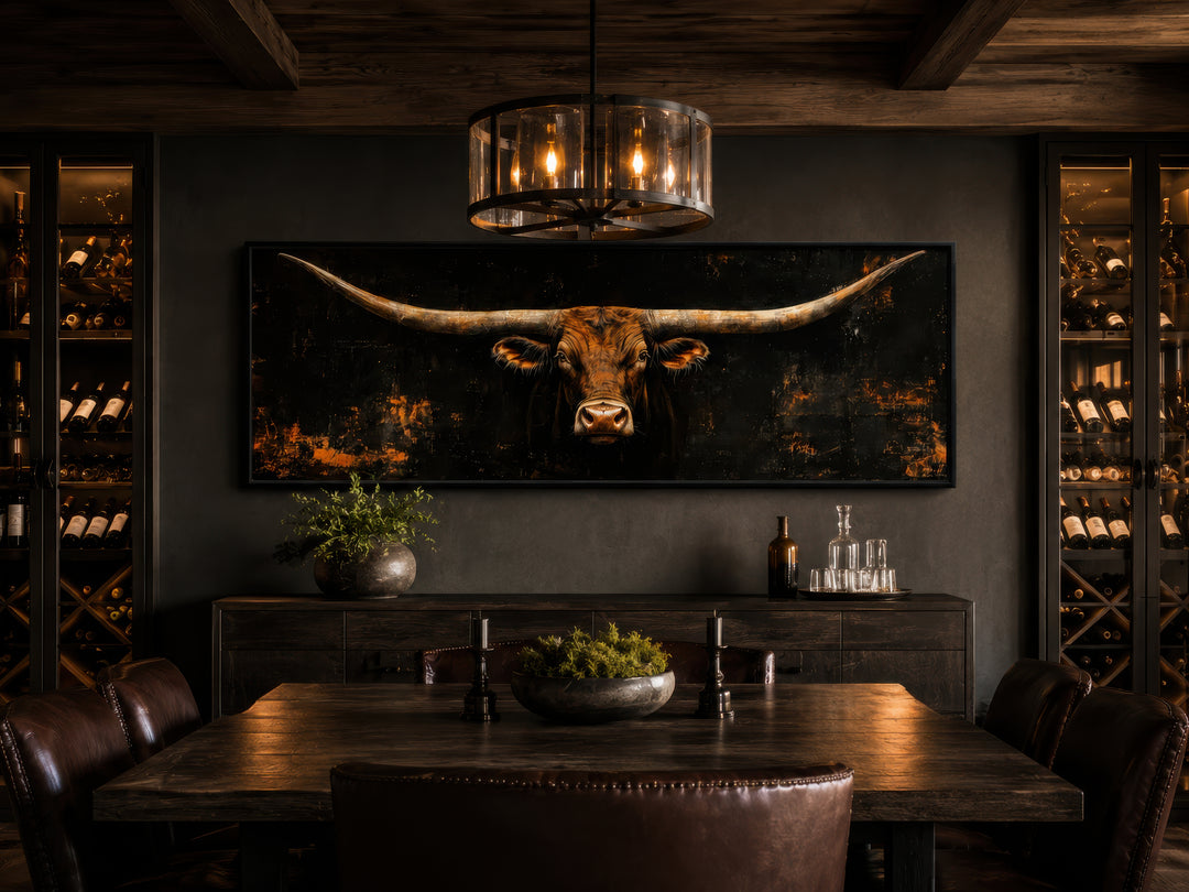 Long horizontal Texas longhorn bull head on black rustic canvas wall art in a dark dining room.