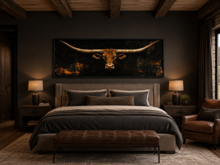 Long horizontal Texas longhorn bull head on black rustic canvas wall art above a bed.