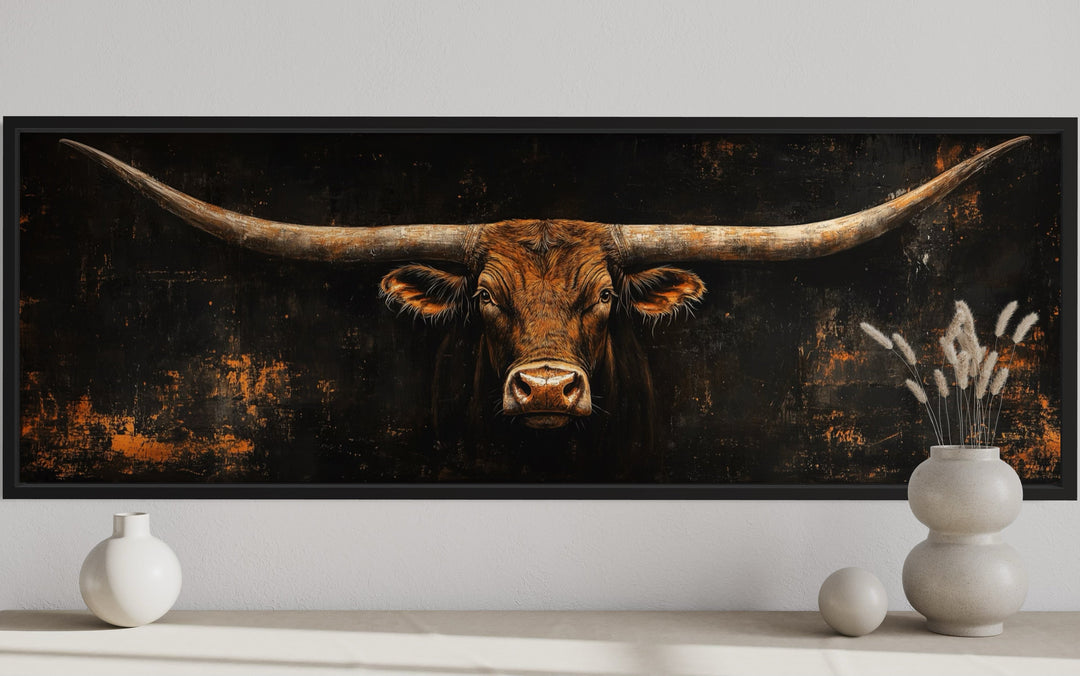 Long horizontal Texas longhorn bull head on black rustic canvas wall art above a console table.