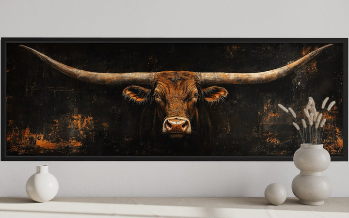 Long horizontal Texas longhorn bull head on black rustic canvas wall art above a console table.