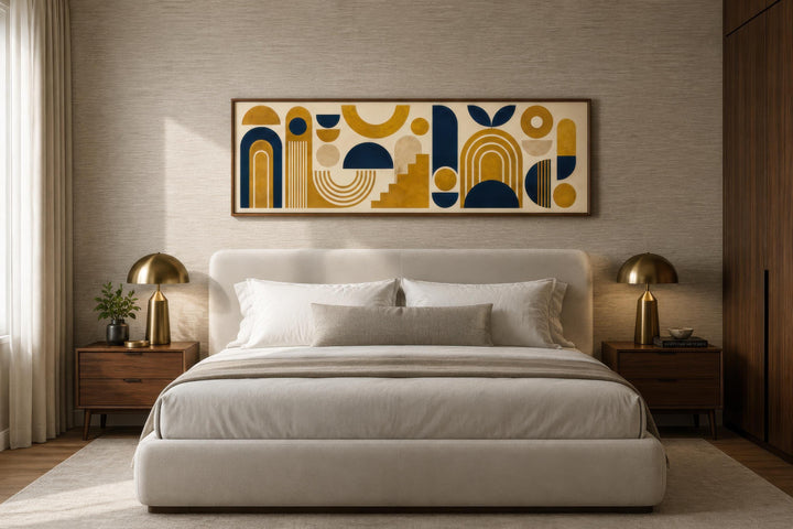 Long narrow Bauhaus canvas wall art with mustard yellow and navy geometric shapes above a bed.