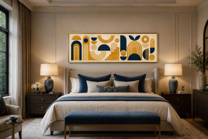 Long narrow Bauhaus canvas wall art with mustard yellow and navy geometric shapes above a bed.