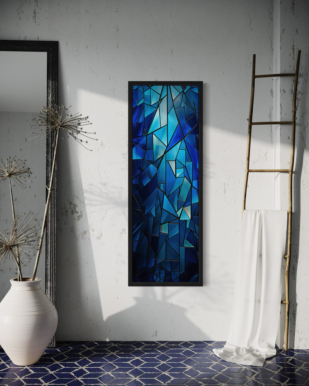 Long narrow navy blue kaleidoscope mosaic abstract vertical framed canvas wall art on a white wall.