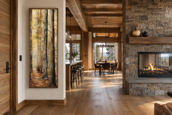 Long narrow vertical framed canvas wall art of a watercolor forest scene in a rustic cabin interior.