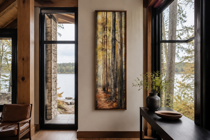 Long narrow vertical framed canvas wall art featuring a watercolor forest scene in a cabin setting.
