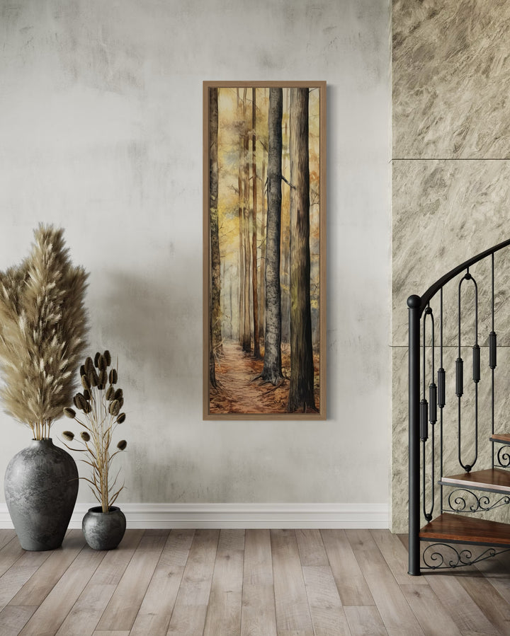 Long narrow vertical framed canvas wall art featuring a watercolor forest scene in a cabin setting.