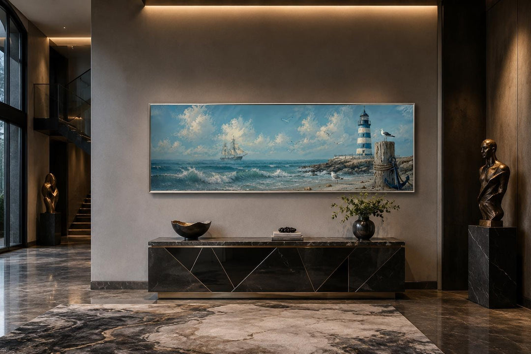 Long sailing ship and lighthouse canvas print in a coastal nautical style above a black console.