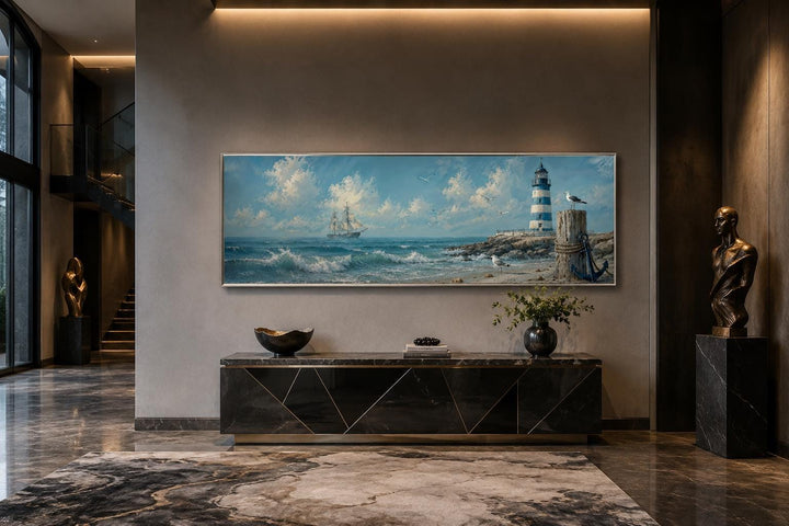 Long sailing ship and lighthouse canvas print in a coastal nautical style above a black console.