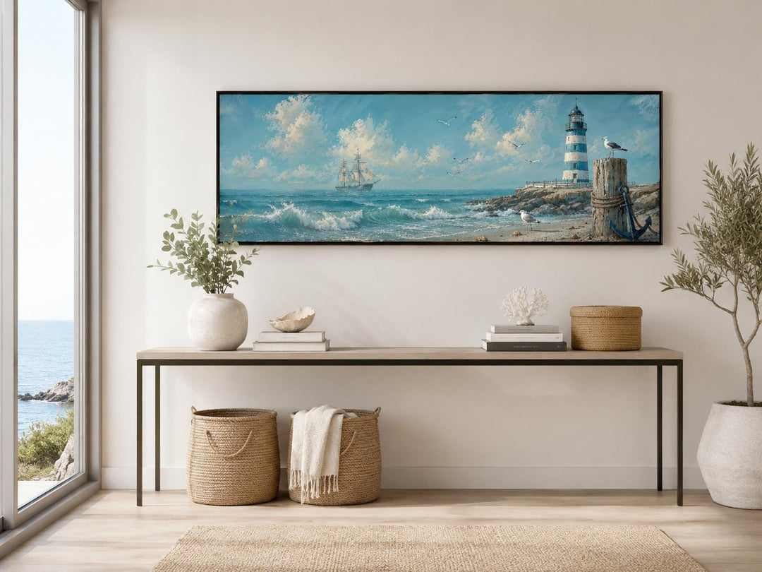 Long panoramic canvas print of a sailing ship and lighthouse on a wall above a console table.