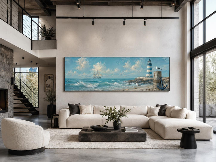 Long panoramic canvas print of a sailing ship and lighthouse in a modern coastal living room.