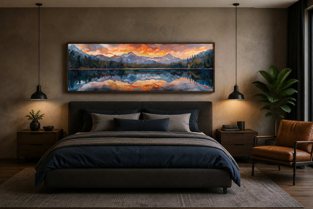 Panoramic framed canvas of a sunset over a mountain lake hanging above a dark upholstered bed.