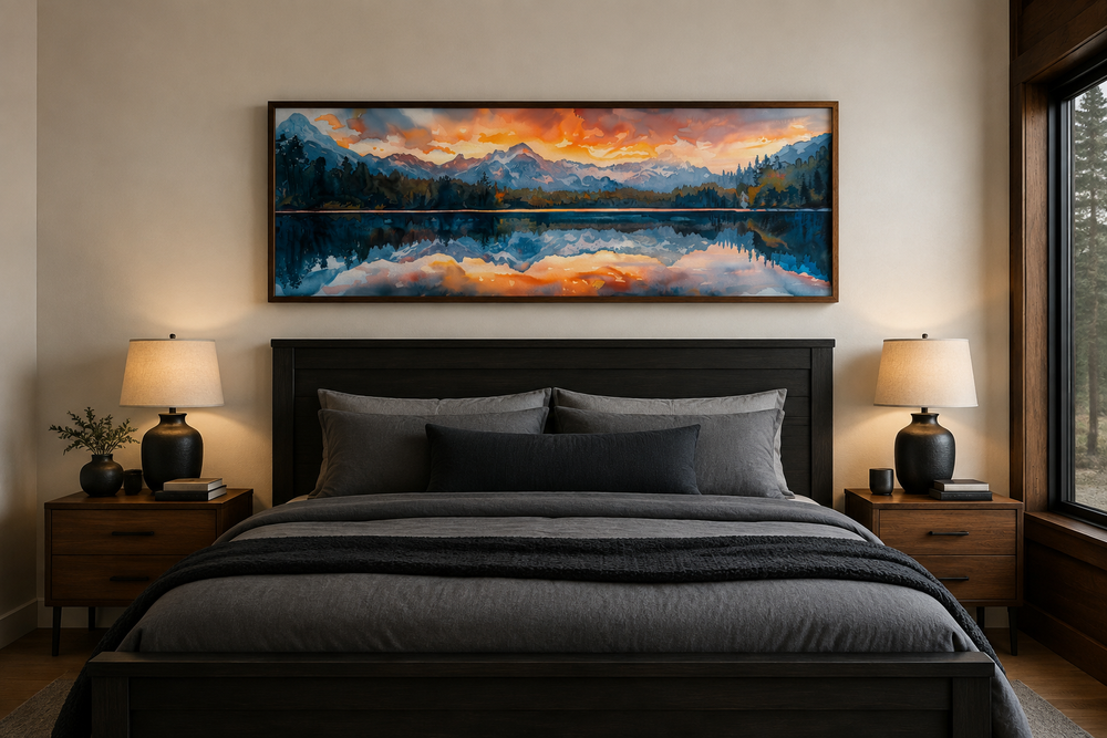 Panoramic framed canvas wall art of a sunset over a mountain lake, hanging above a dark wood bed.
