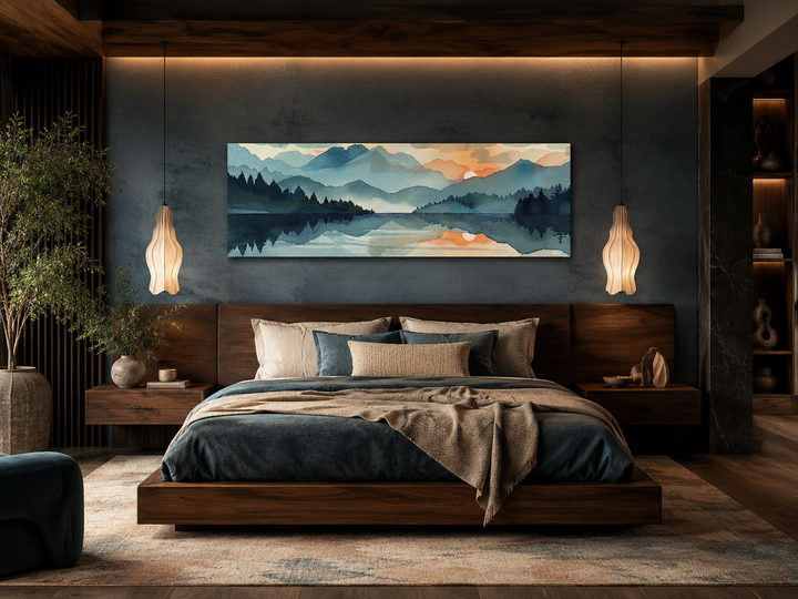 Long horizontal watercolor mountain lake sunset canvas wall art hanging above a bed.