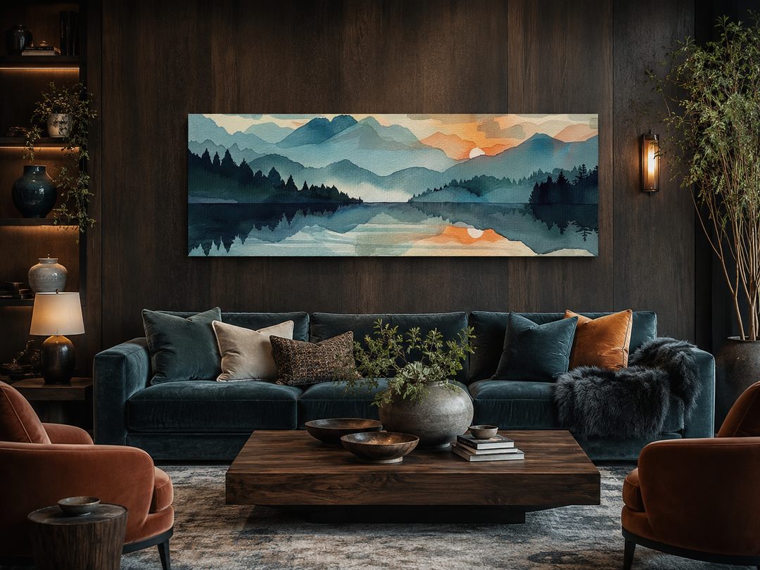 Long horizontal watercolor canvas of a mountain lake sunset above a dark velvet sofa.