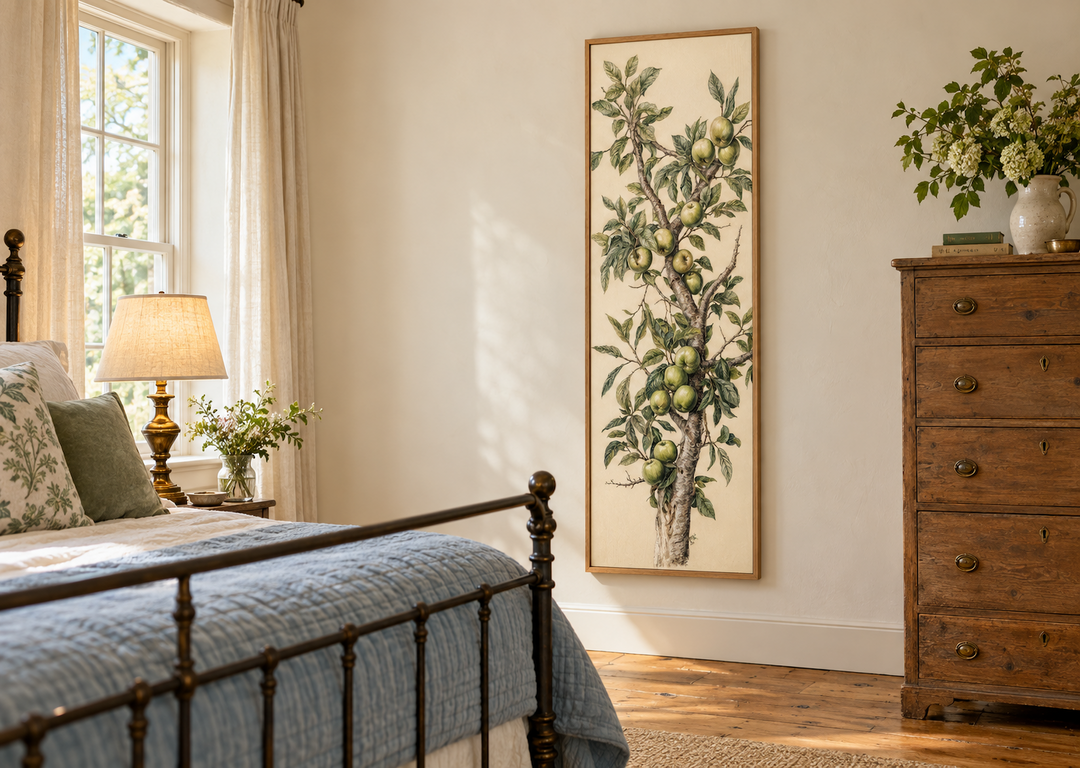 Long vertical framed canvas wall art featuring a botanical apple tree branch in a bedroom.