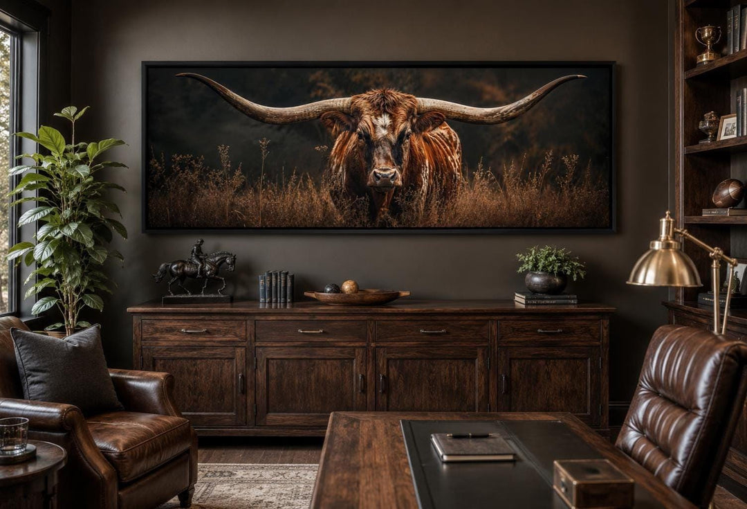Longhorn Bull wall art with sweeping horns in golden grass, hung in a dark wood office setting.