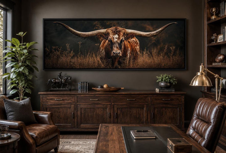Longhorn Bull wall art with sweeping horns in golden grass, hung in a dark wood office setting.