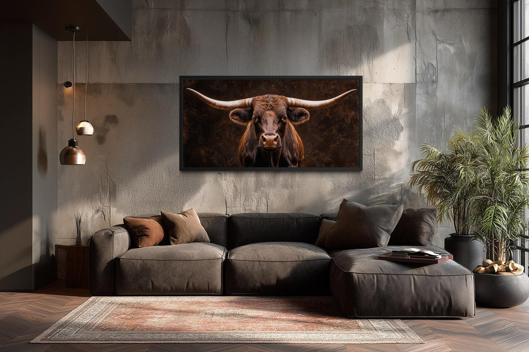 Extra large Longhorn bull canvas print in a black frame above a modern sofa in a rustic living room.
