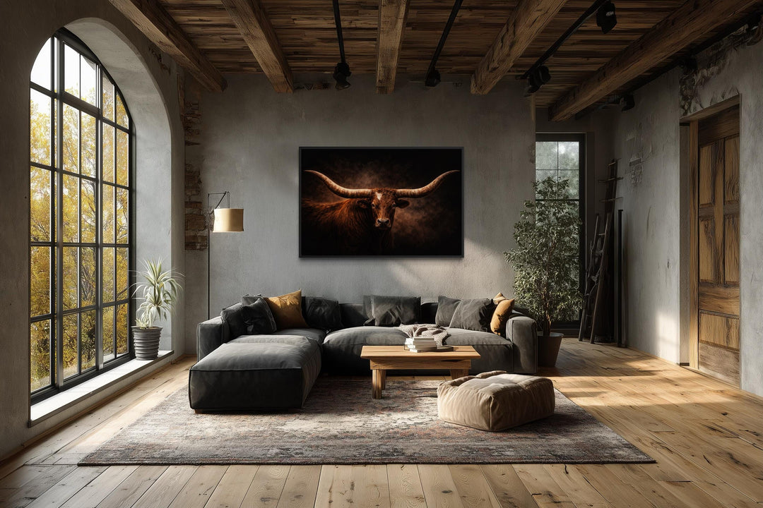 A framed canvas print of a longhorn bull with wide horns hangs in a rustic, modern living room.
