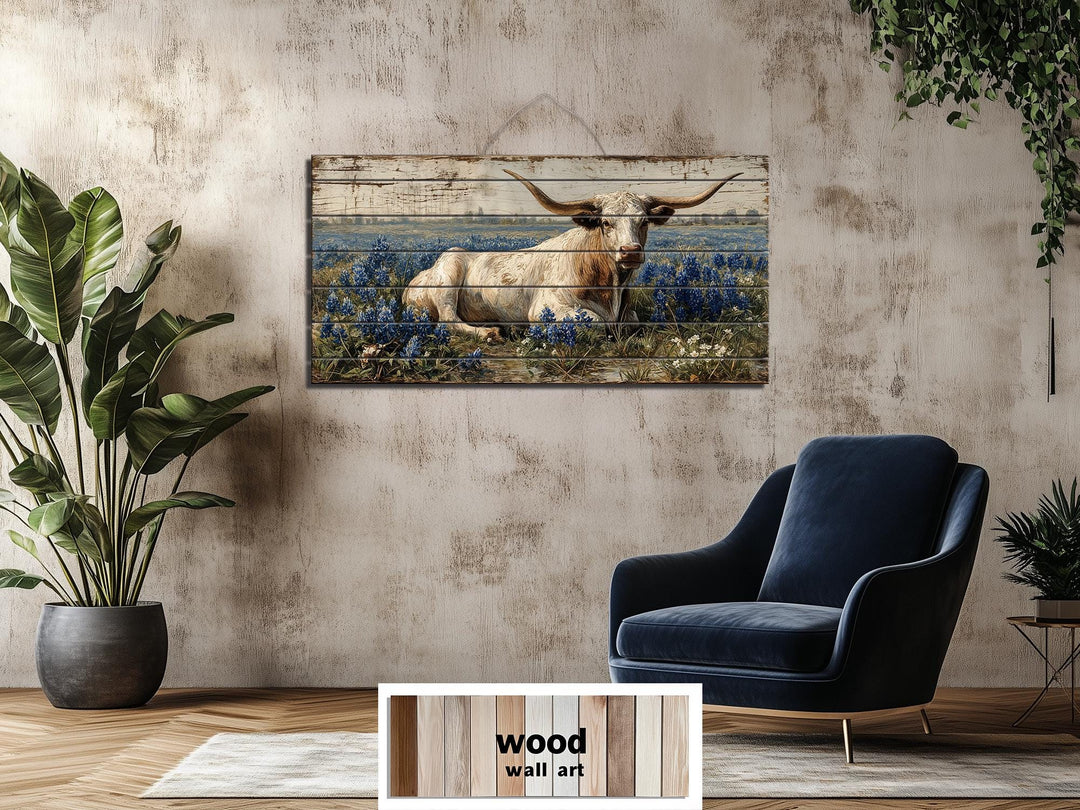 Longhorn in bluebonnet field distressed wood wall art hanging in a rustic farmhouse living room.