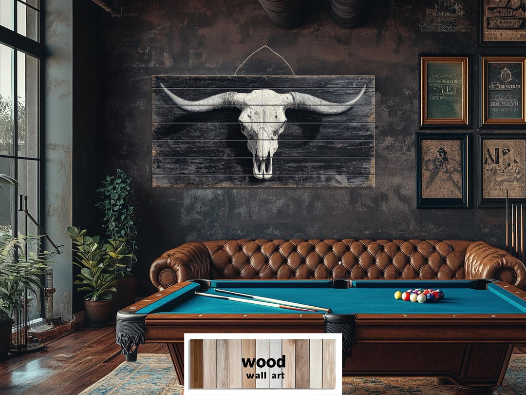 A rustic longhorn skull printed on a distressed wood panel, centered above a leather sofa.
