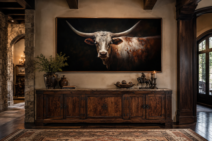 Longhorn bull portrait canvas art with sweeping horns on a dark background in a rustic living room.