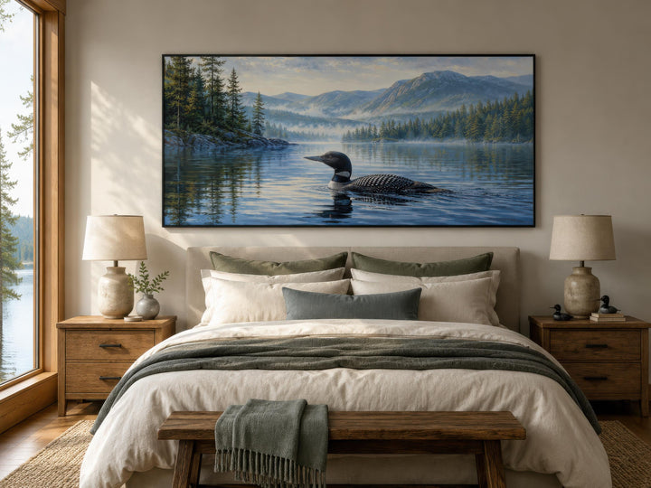 Loon wall art canvas of a common loon on a misty lake with mountains above a bed in a bedroom.