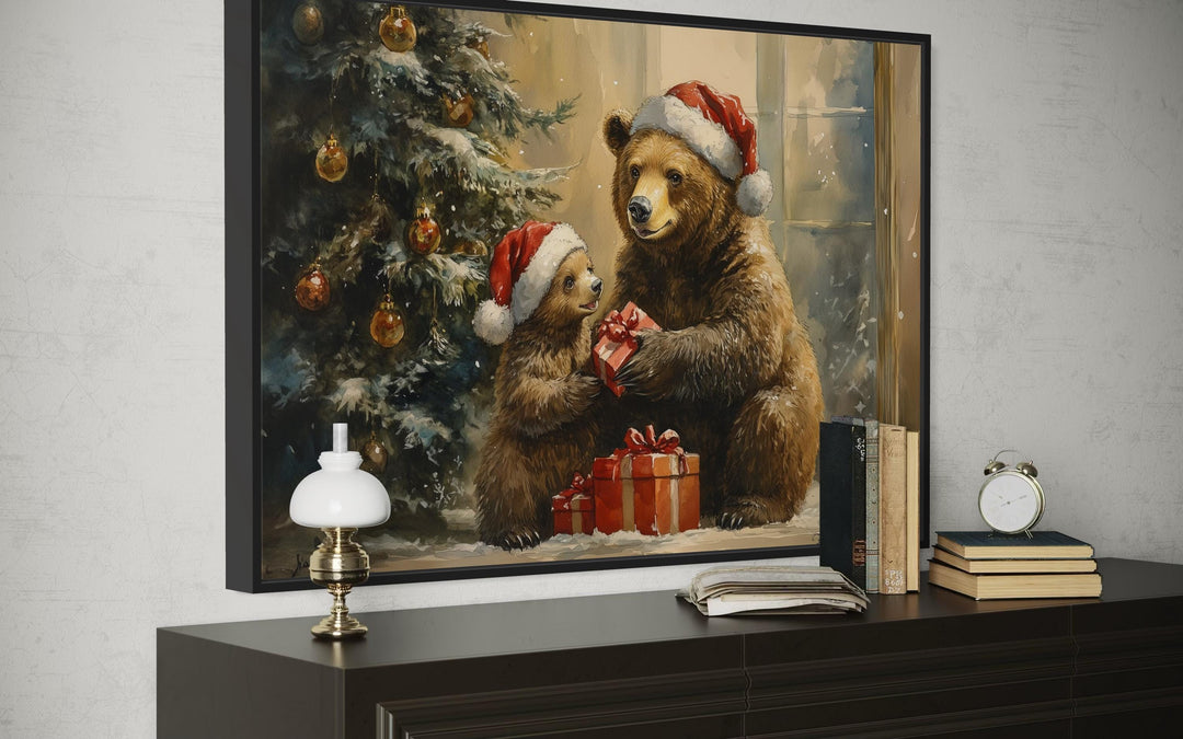 Framed wall art of a mama bear and cub in Santa hats exchanging gifts by a Christmas tree.