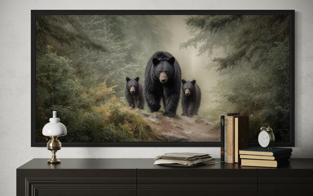 Mama bear and two cubs in a misty pine forest canvas wall art displayed above a dark wood console.
