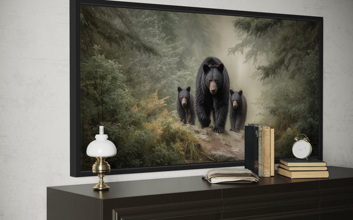 Mama bear and two cubs in a misty pine forest canvas wall art framed above a dark wood dresser.